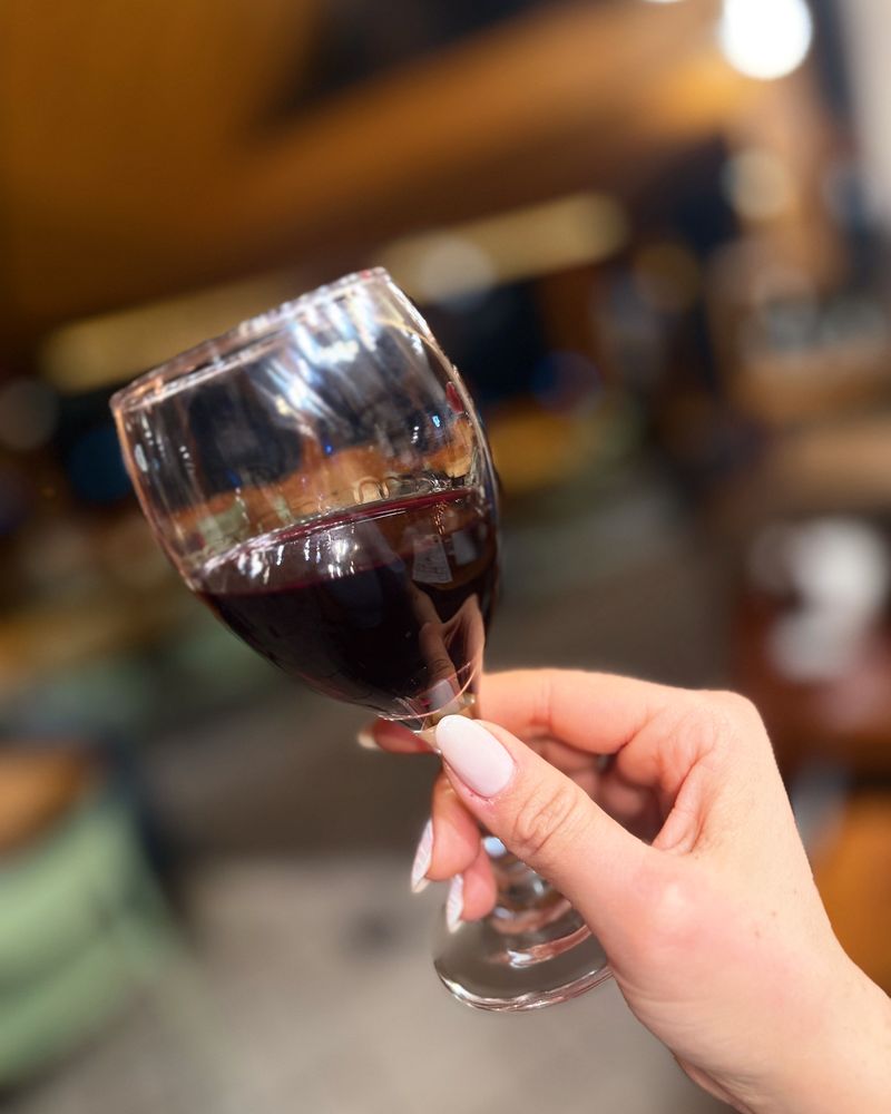 Una copa de vino tinto en la mano, durante la degustación.